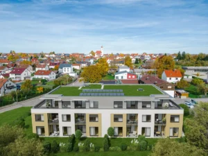 Luftaufnahme eines Mehrfamilienhauses in Gerstetten-Dettingen mit begrüntem Dach, PV-Anlagen und einer Grünfläche um das Haus. – Es handelt sich um ein Rendering.
